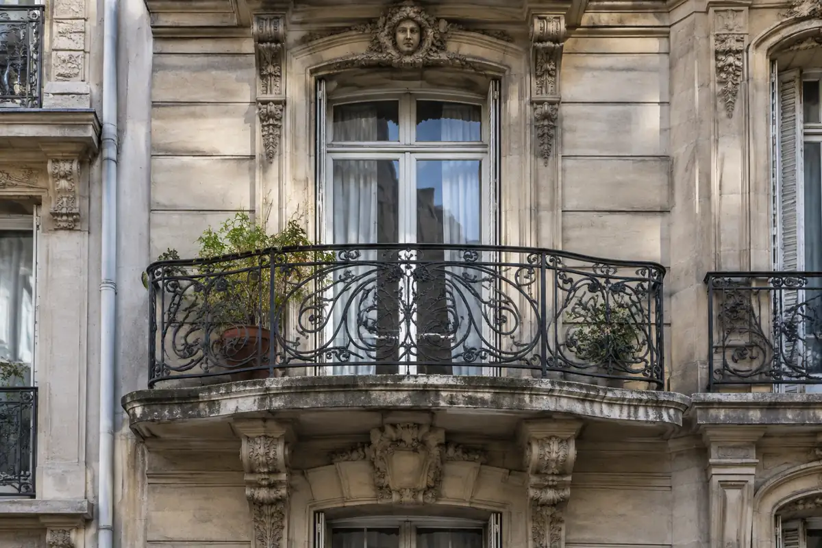 Façade de la Belle Époque avec balcon en fer forgé aux lignes courbes
