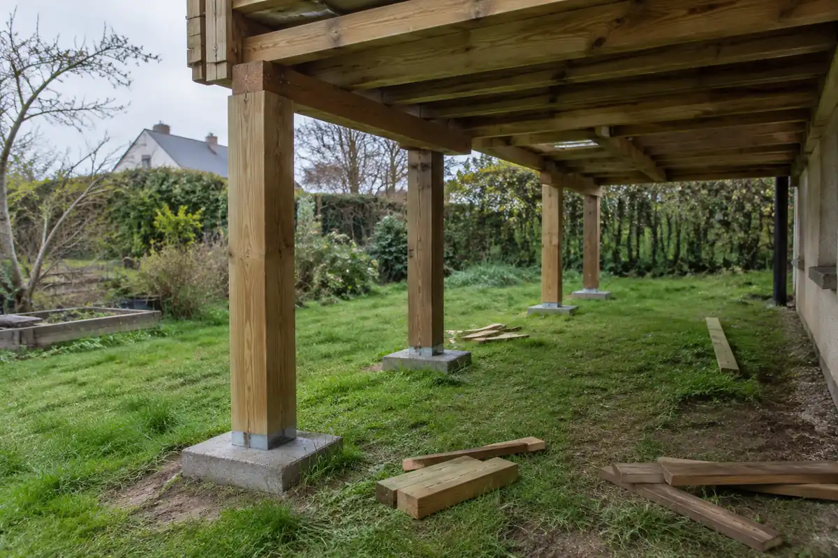 Poteaux en bois sur des plots béton sous la structure d'une terrasse en construction
